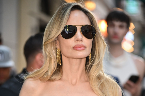 Angelina Jolie attends a premiere in sunglasses and bright blonde hair.